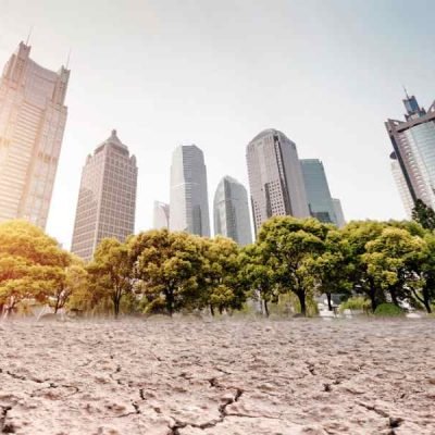 A city looks over a cracked earth landscape